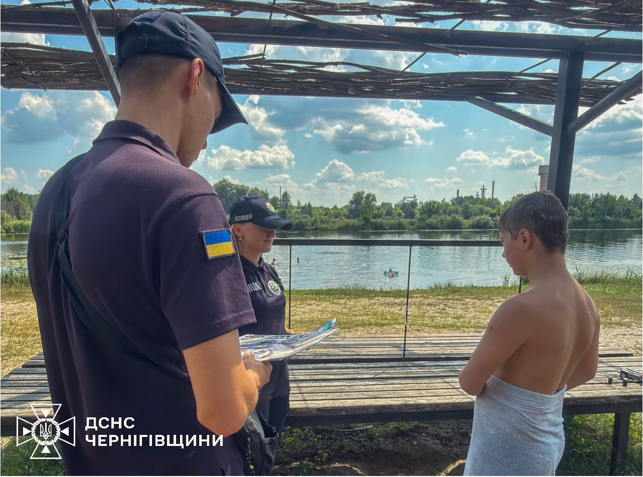 Фотографія рятувальники говорять з х хлопчиком біля водойми